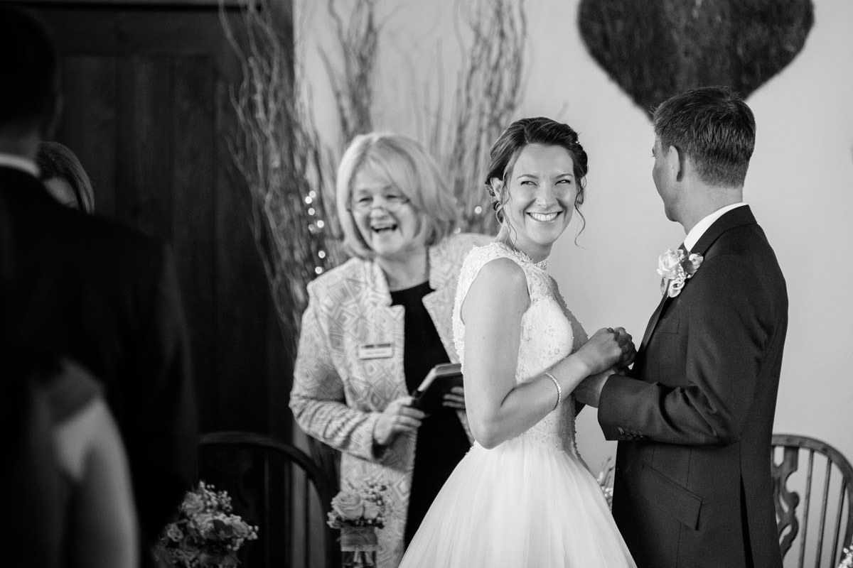 Bride laughing during wedding ceremony at Dodmoor House