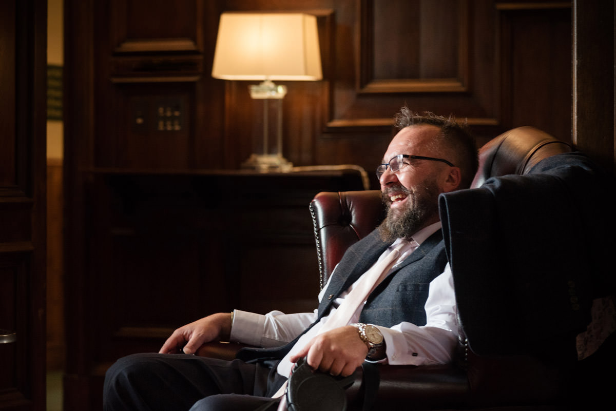 Groom sitting in a chair before the ceremony at Stoke Rochford Hall, Grantham
