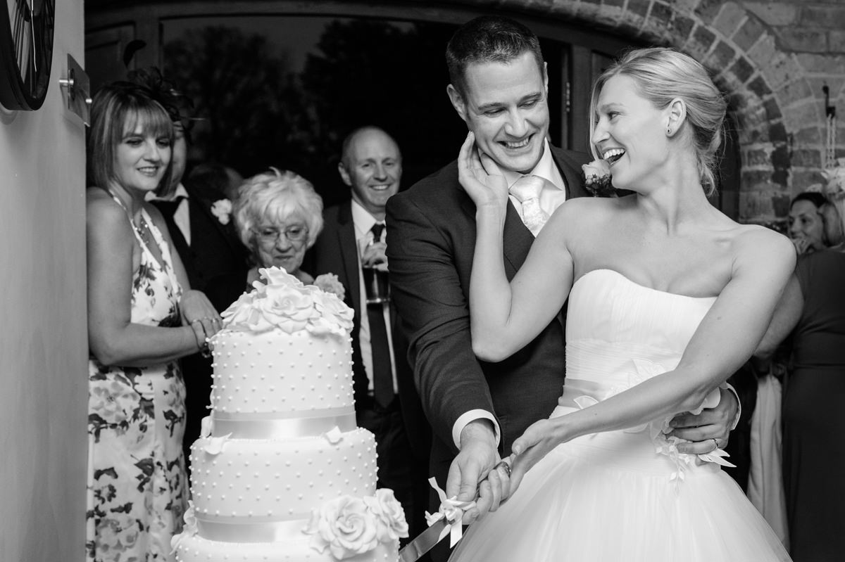 Bride and groom laughing after cutting their cake