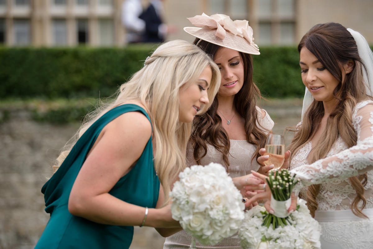 Bride showing her wedding ring to her friends at Rushton Hall