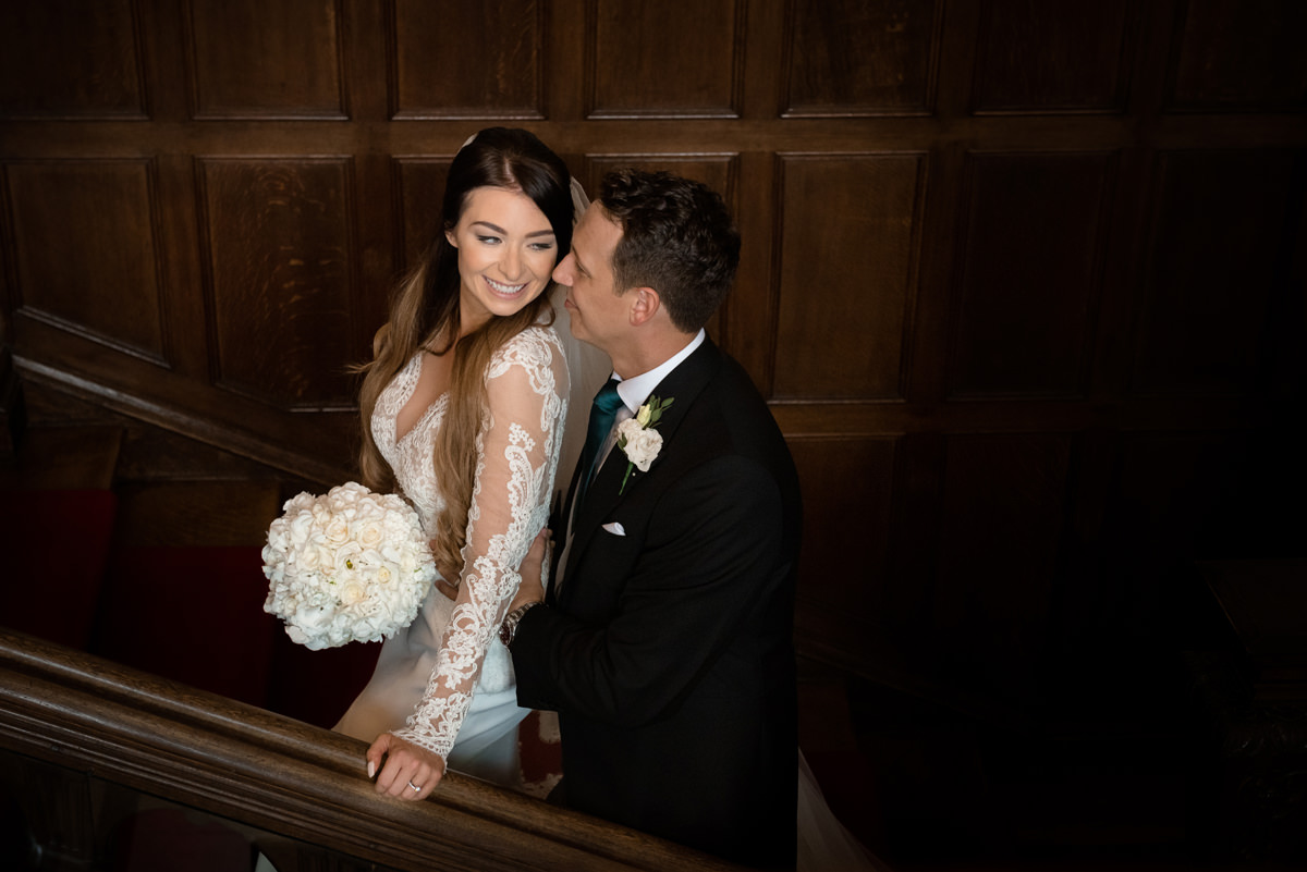 Bride and groom on the staircase at Rushton Hall