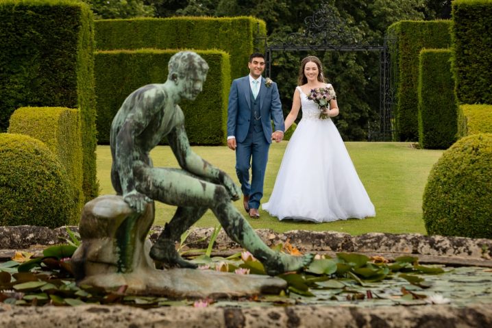 bride and groom at the lily pond at Holdenby House