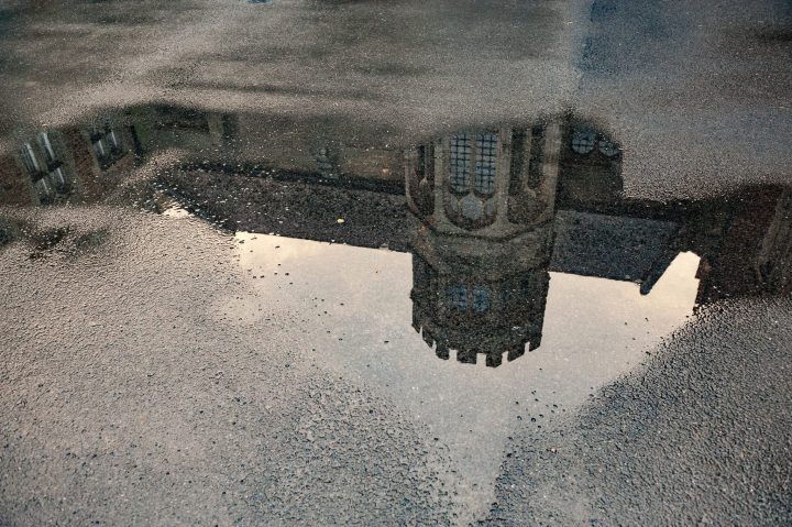 Reflection of Fawsley Hall in a puddle