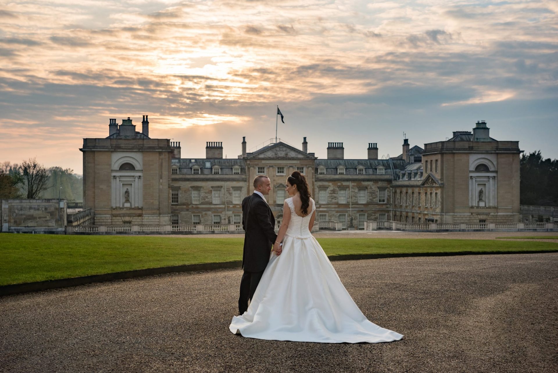 Bride and groom in front of Woburn Abbey at sunset