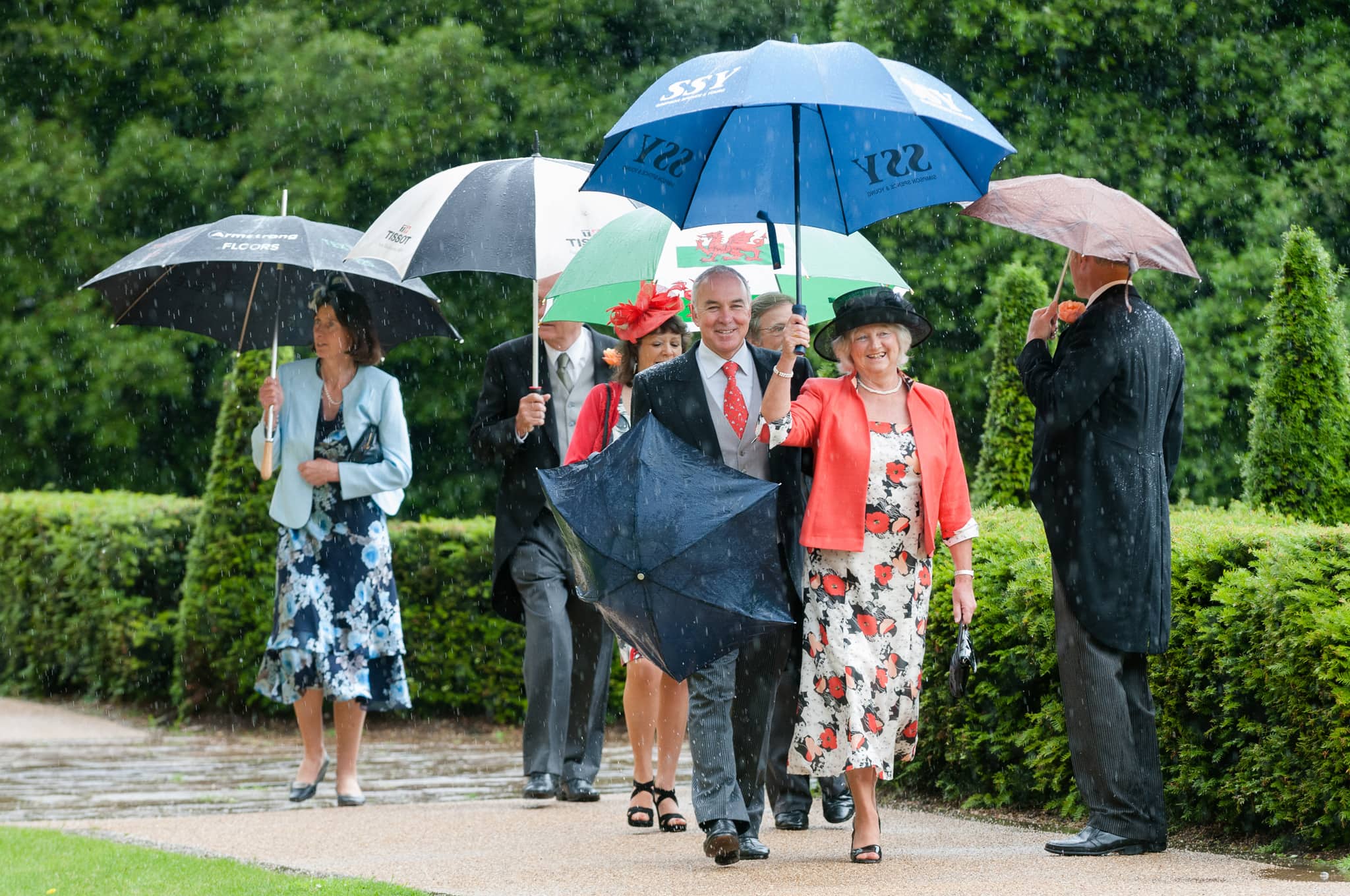 Wedding guests arriving at church in the rain