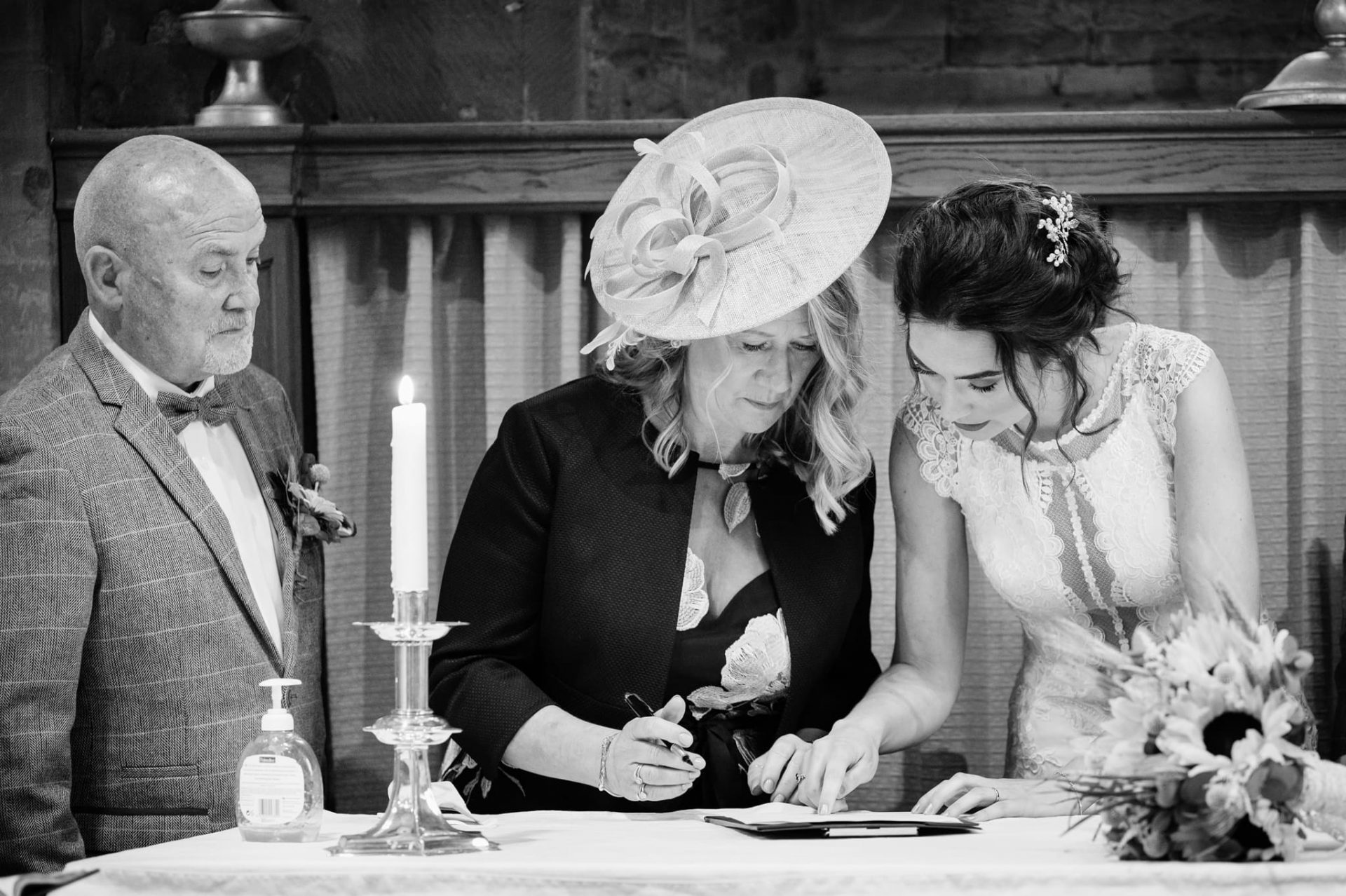 Mother of the bride signing the register as a witness at Dallington church