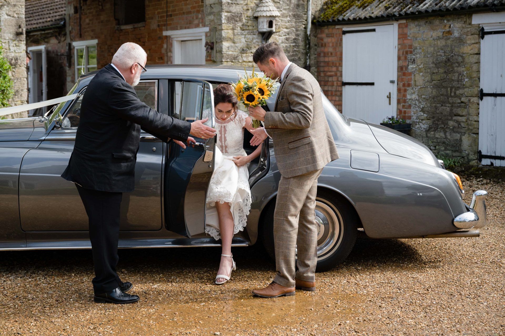 Bride getting out of the car at Hill Farm House in Brigstock