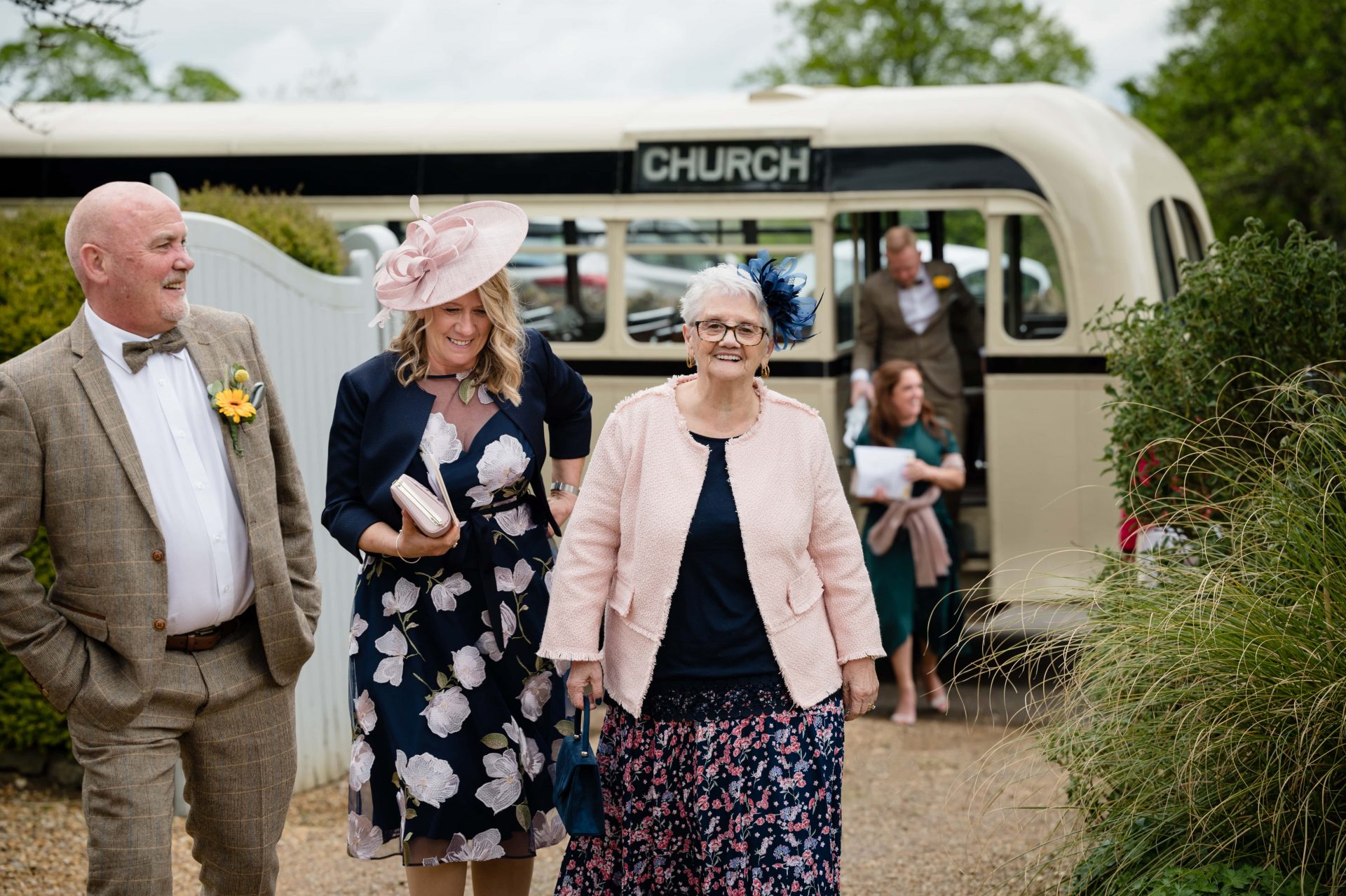 Wedding guiests arriving on a vintage bus at Hill Farm House in Brigstock