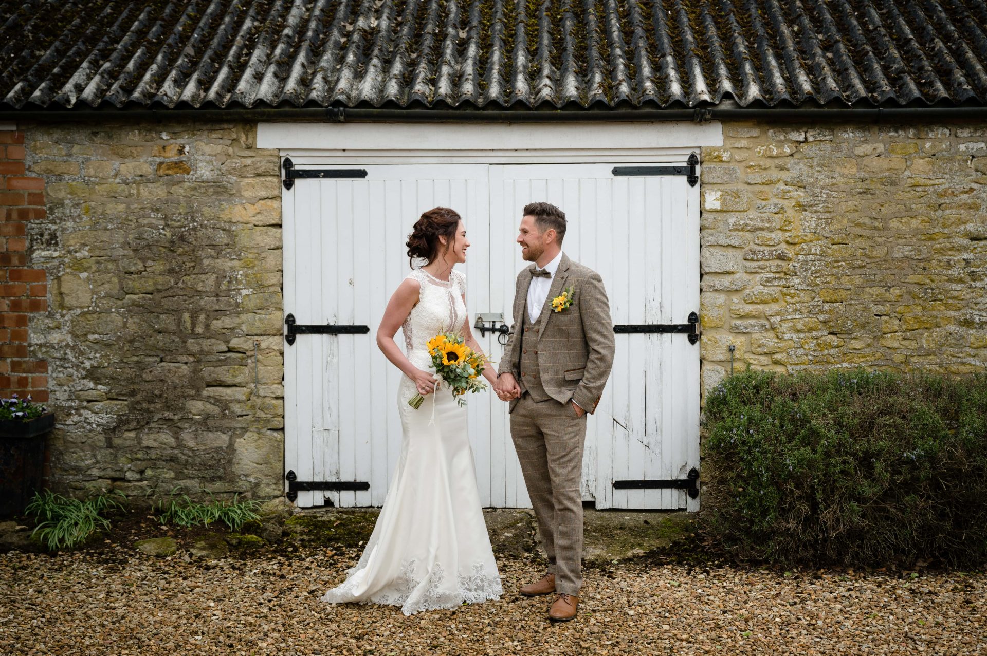 Bride and groom in front of white painted doors at Hill Farm House in Brigstock