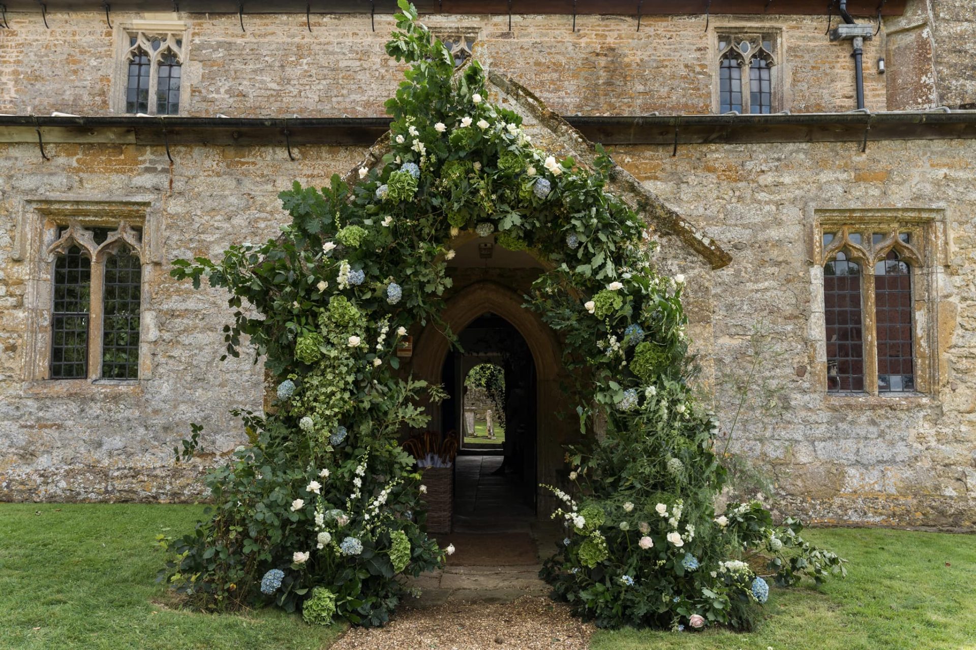 Wild wedding floral arch at church entrance