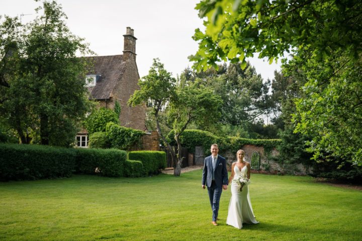Bride & groom walking on lawn at Dodmoor House