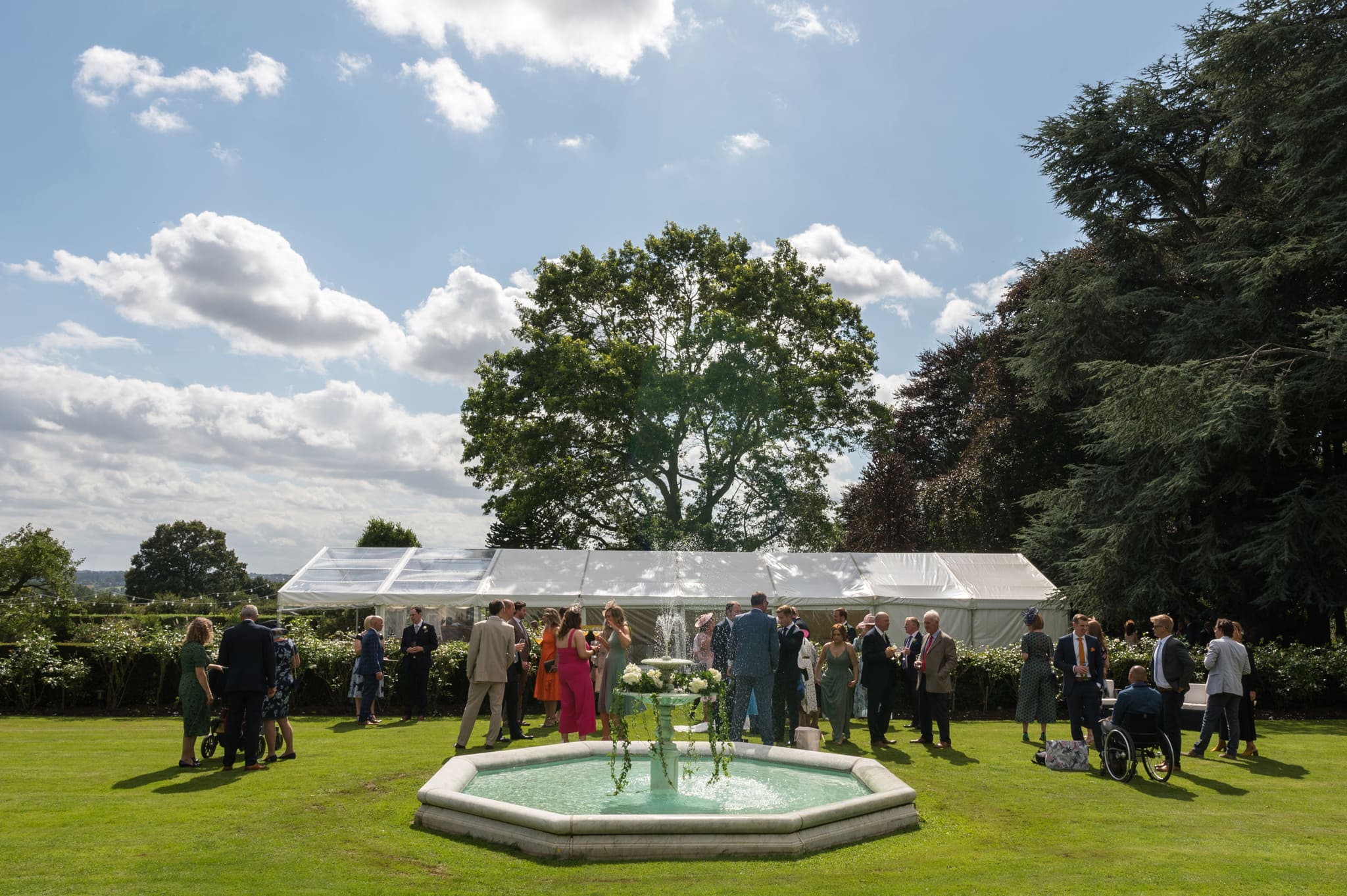 Drinks reception by the fountain at New Lodge Lawns