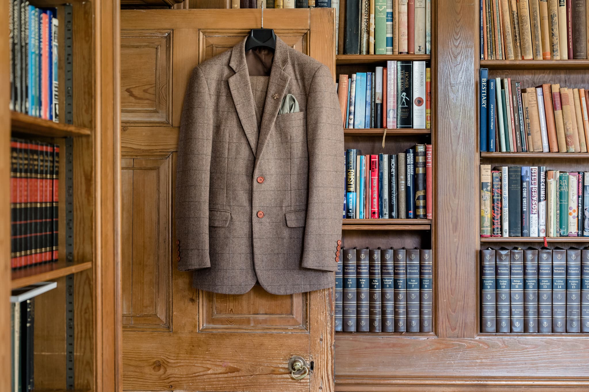 Groom's suit jacket hanging on the library door at Sutton Bonington Hall