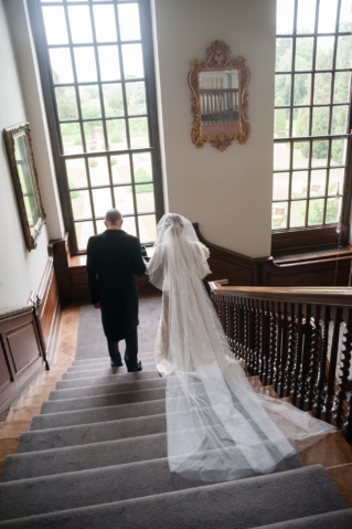 Bride and her dad walking down the staircase