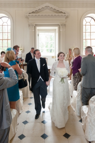 Bride and groom walking down the aisle at Chicheley Hall