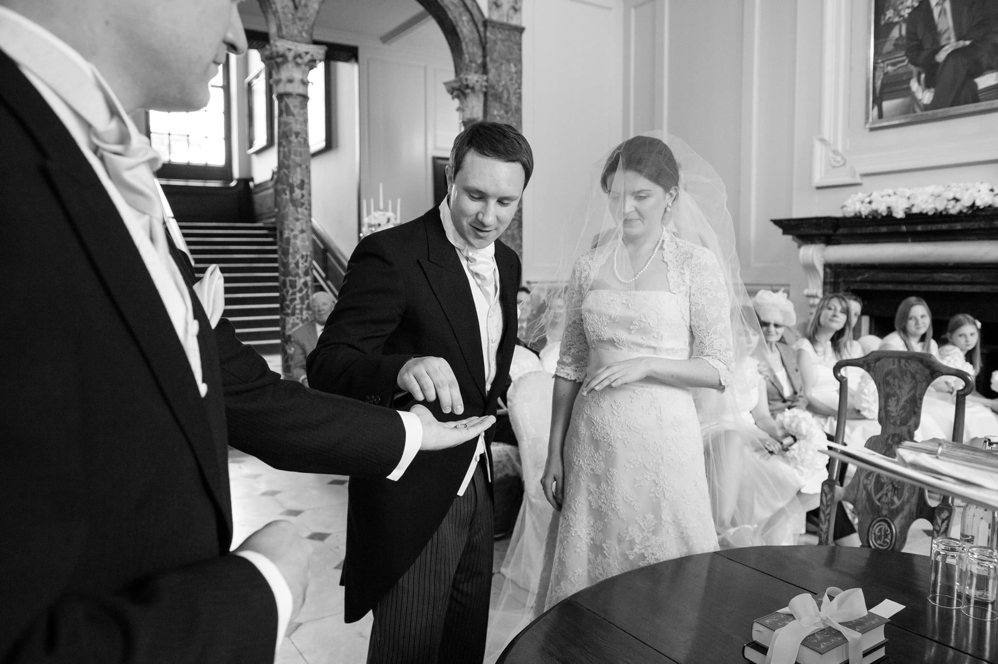 Groom taking wedding ring from best man ready to give it to the bride