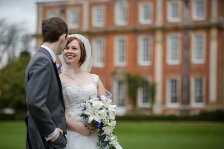 Portrait of bride and groom with Chicheley Hall out of focus in the background