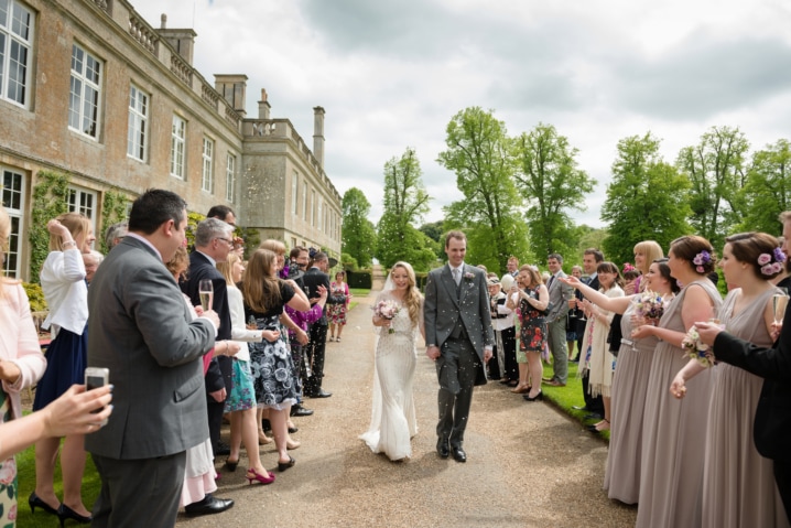 Confetti being thrown over newlyweds outside Boughton House