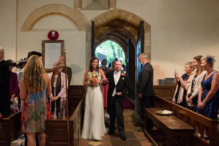 Bride being walked down the aisle by her grandfather at Dodford church