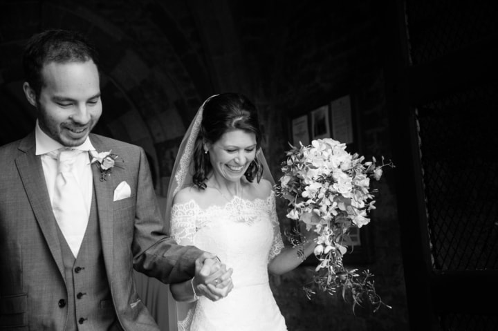 Bride and groom walking out of Dodford Manor church