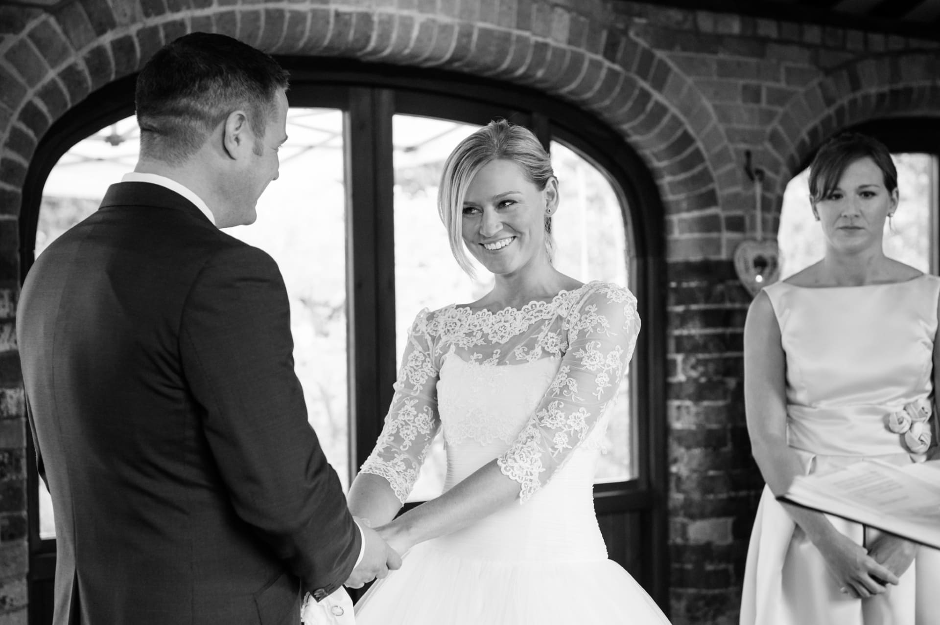 Bride smiling at the groom during a wedding ceremony at Dodmoor House