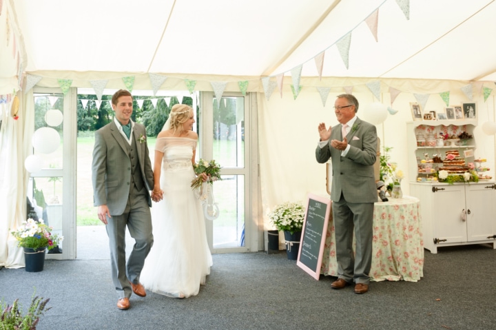 Bride and groom entering marquee for the wedding breakfast