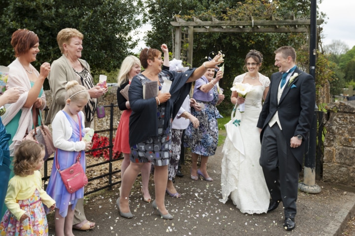 Confetti being thrown over couple as they leave Rushton church