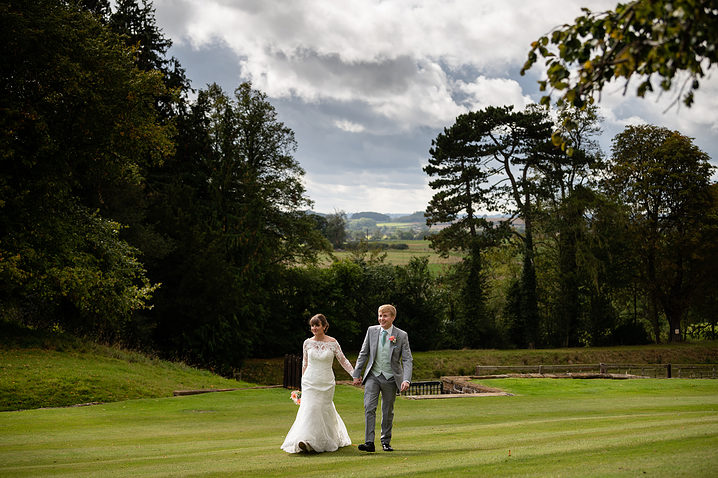 Bride and groom walking through the grounds of Holdenby House