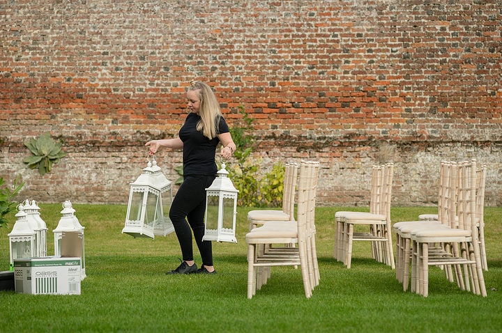 Deene Park's wedding manager Georgina setting up the aisle for a wedding ceremony in the walled garden