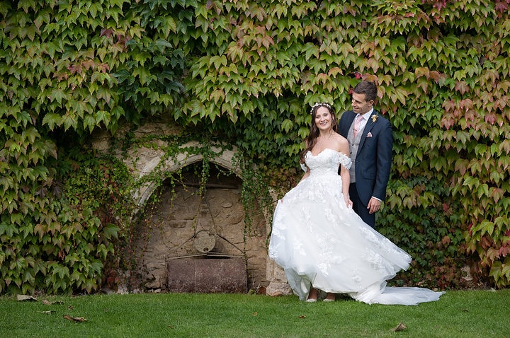 Bride and groom in front of an ivy-clad wall at Notley Abbey