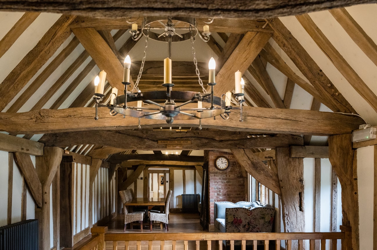 The communal area upstairs at Cain Manor with oak beams and cast iron chandeliers