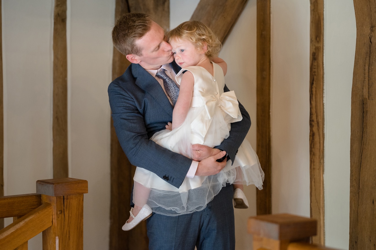 Flower girl getting a cuddle from her dad
