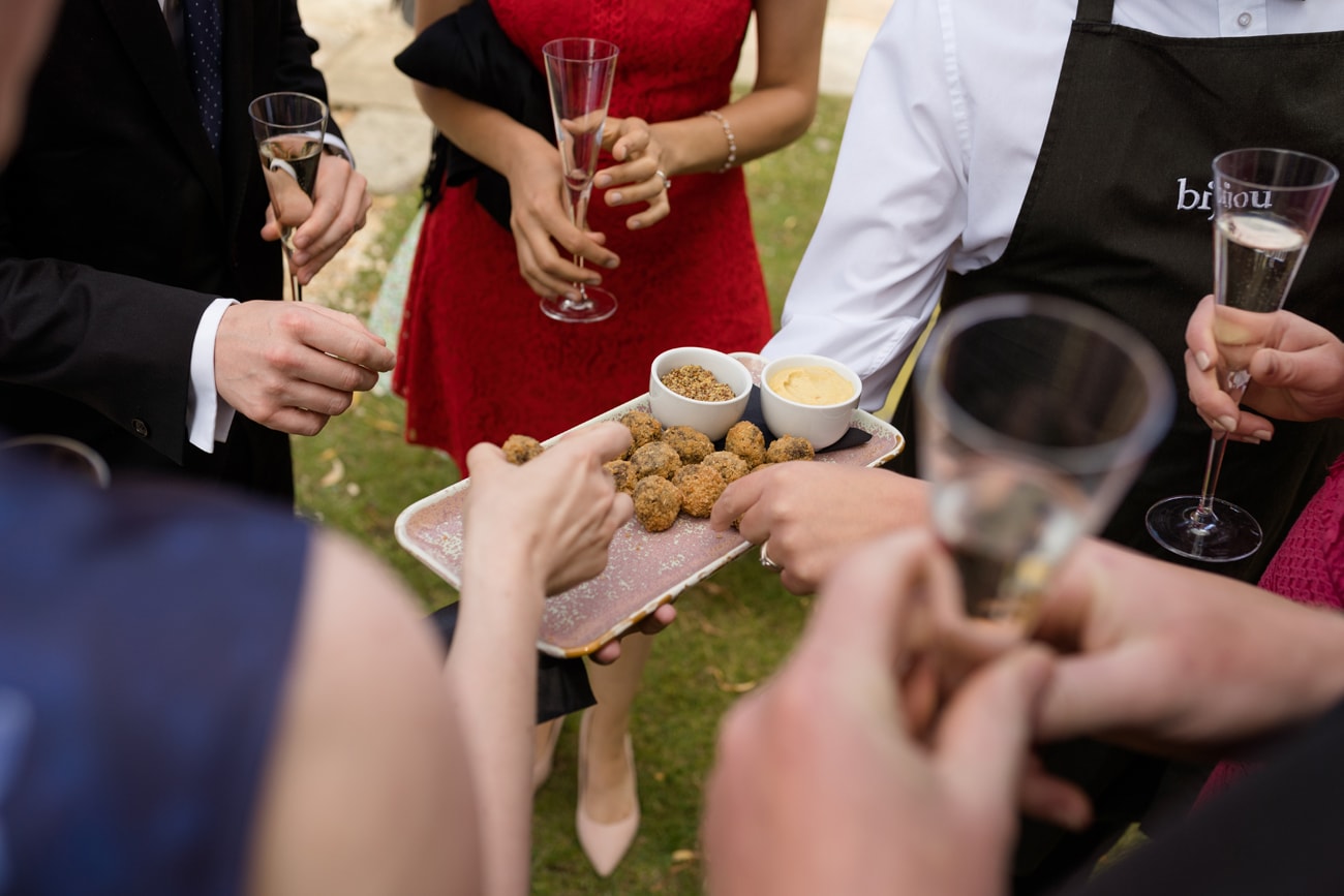 A close up photo of guests' hands taking canapes from a plate