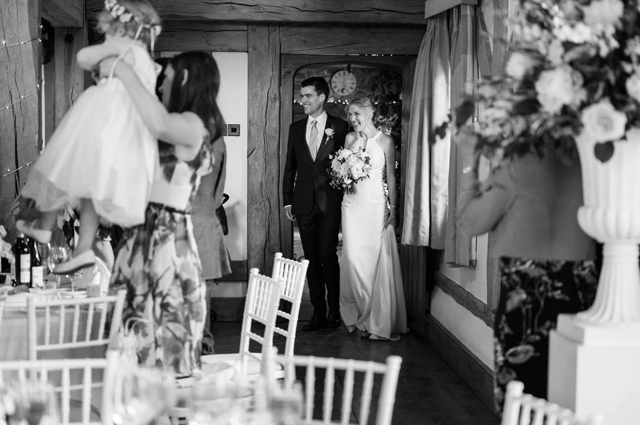 Bride and groom being welcomed into the music room at Cain Manor for their wedding breakfast