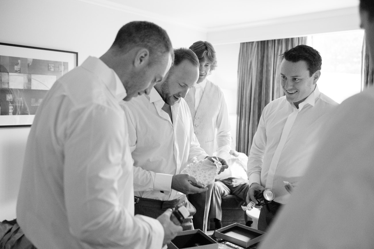 Groomsmen opening gifts from the groom