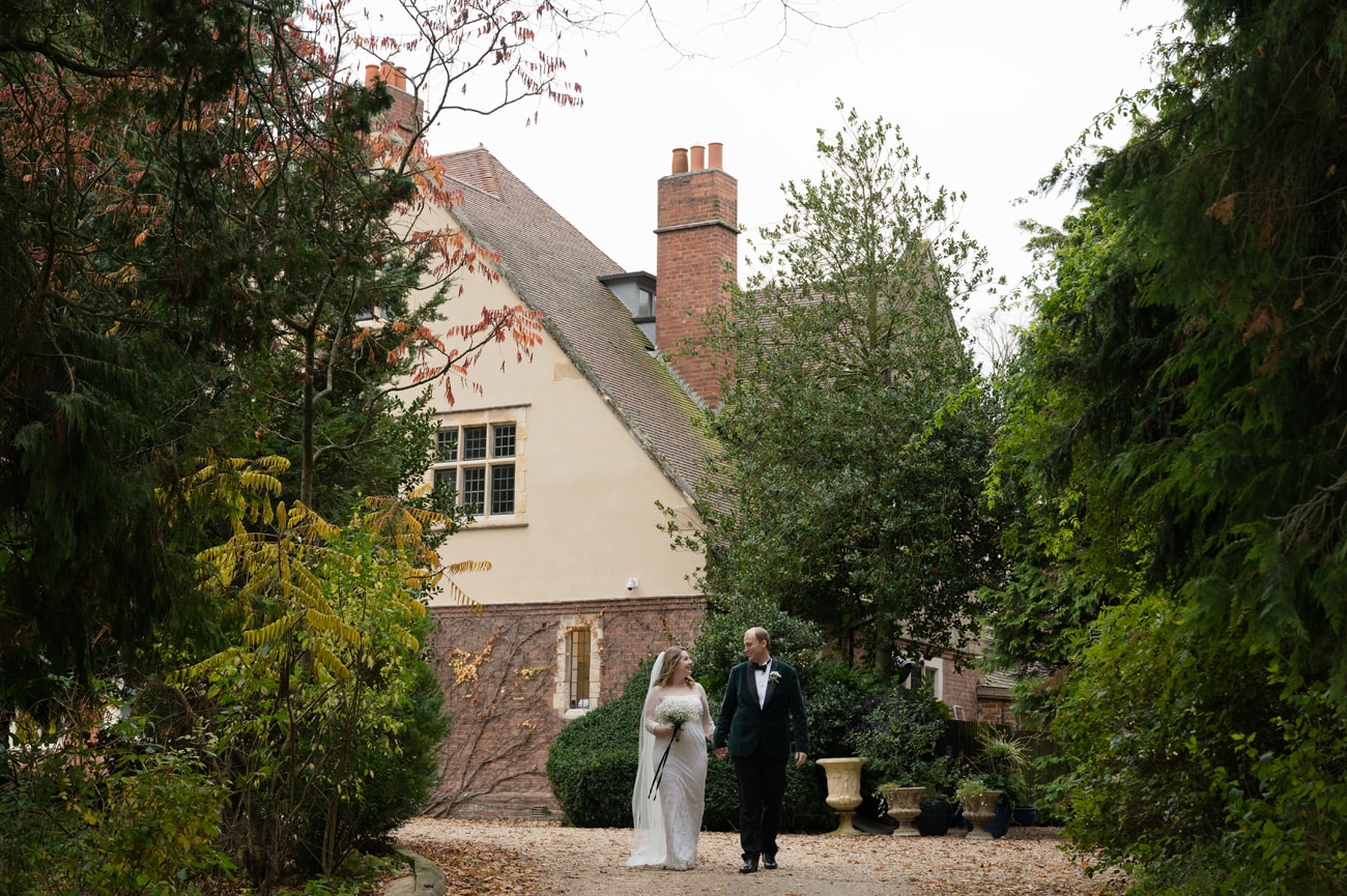 Bride and groom walking in front of Plum Park Manor