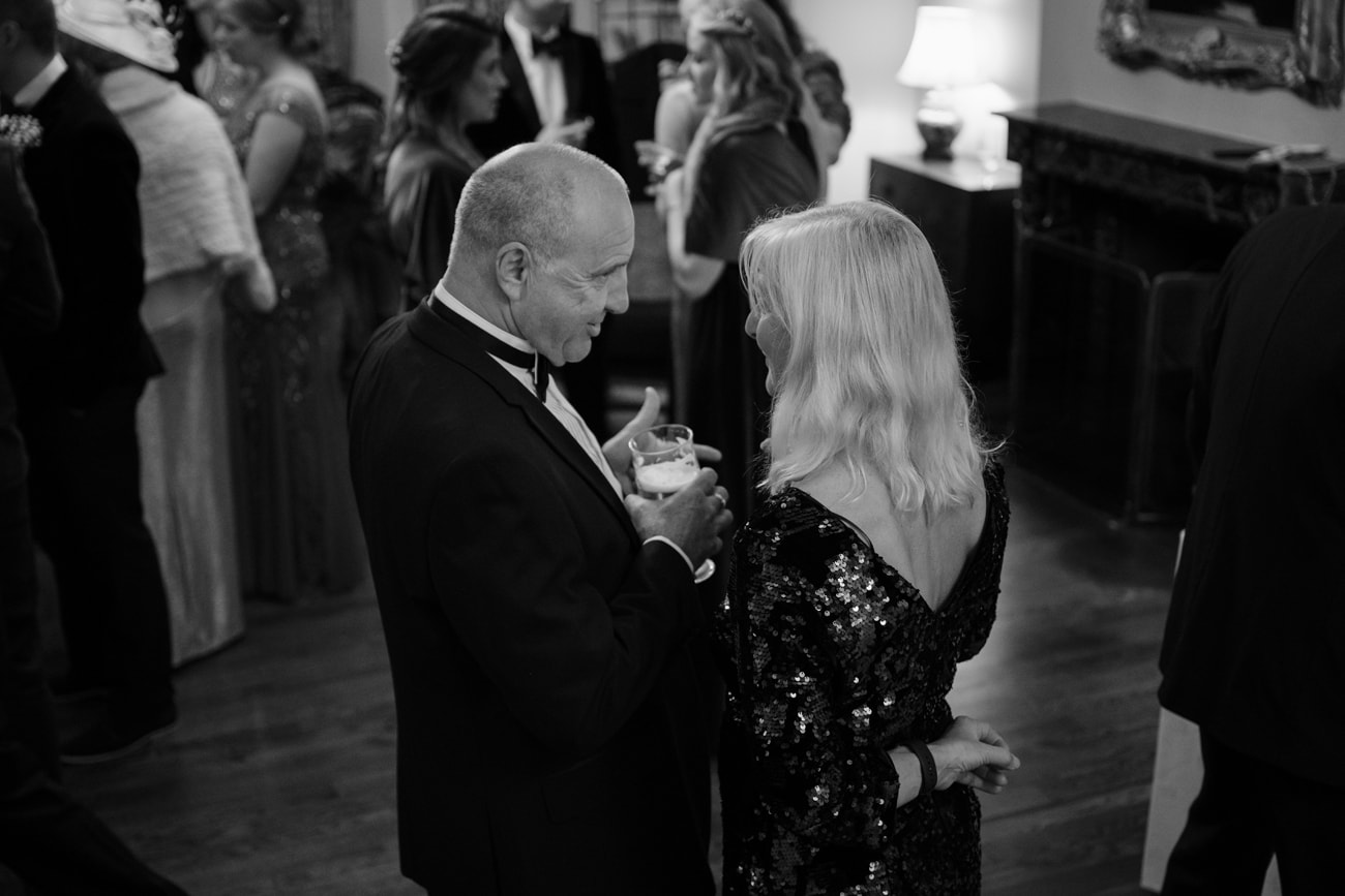 Male and female wedding guest chatting together
