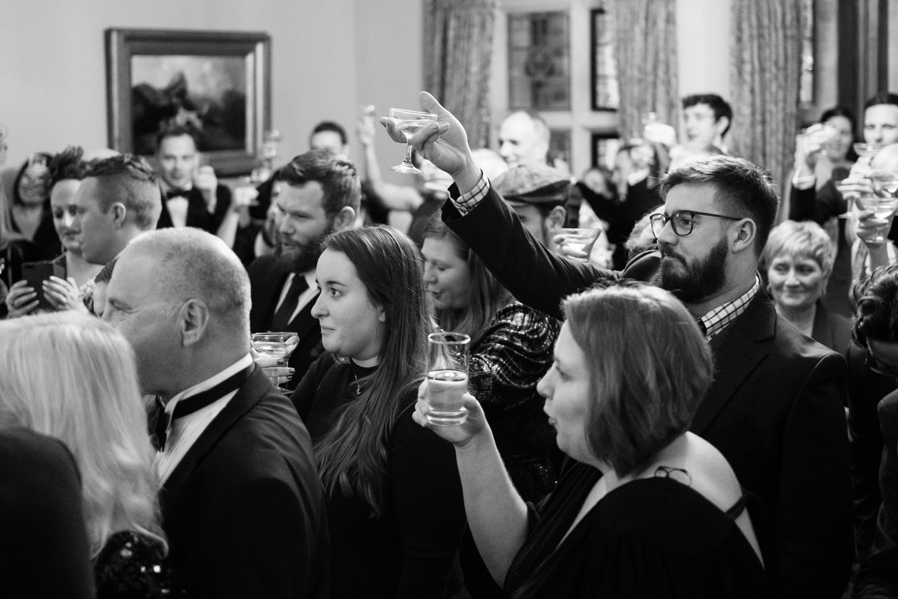 Wedding guests raising a champagne coupe to toast a speech