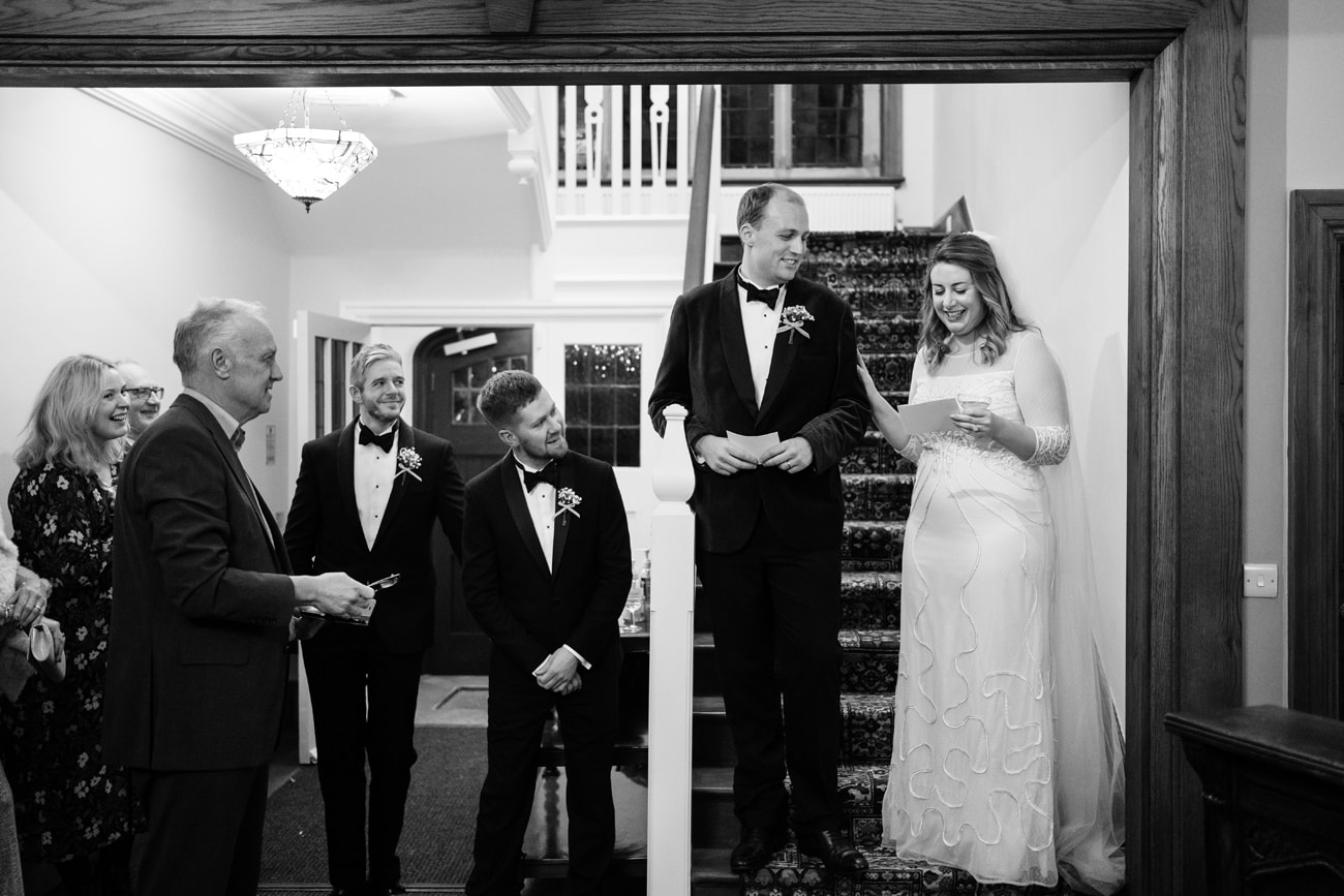 Bride and groom making a joint speech on the staircase at Plum Park Manor
