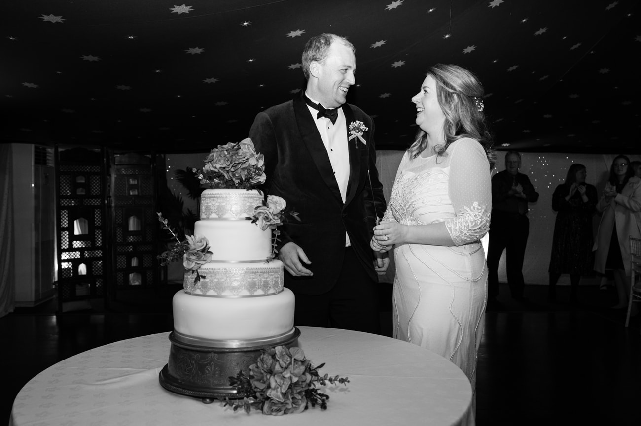 Bride and groom holding a knife ready to cut their wedding cake