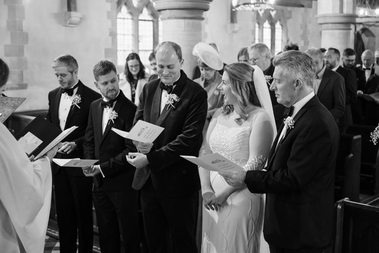 Bride and groom singing a hymn at St Michael's church in Silverstone