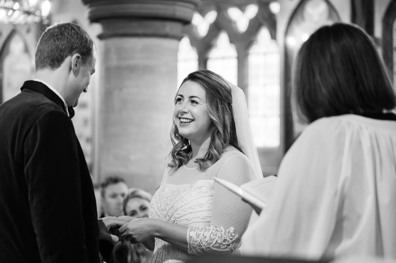 Bride giving the groom his wedding ring at St Michael's church in Silverstone