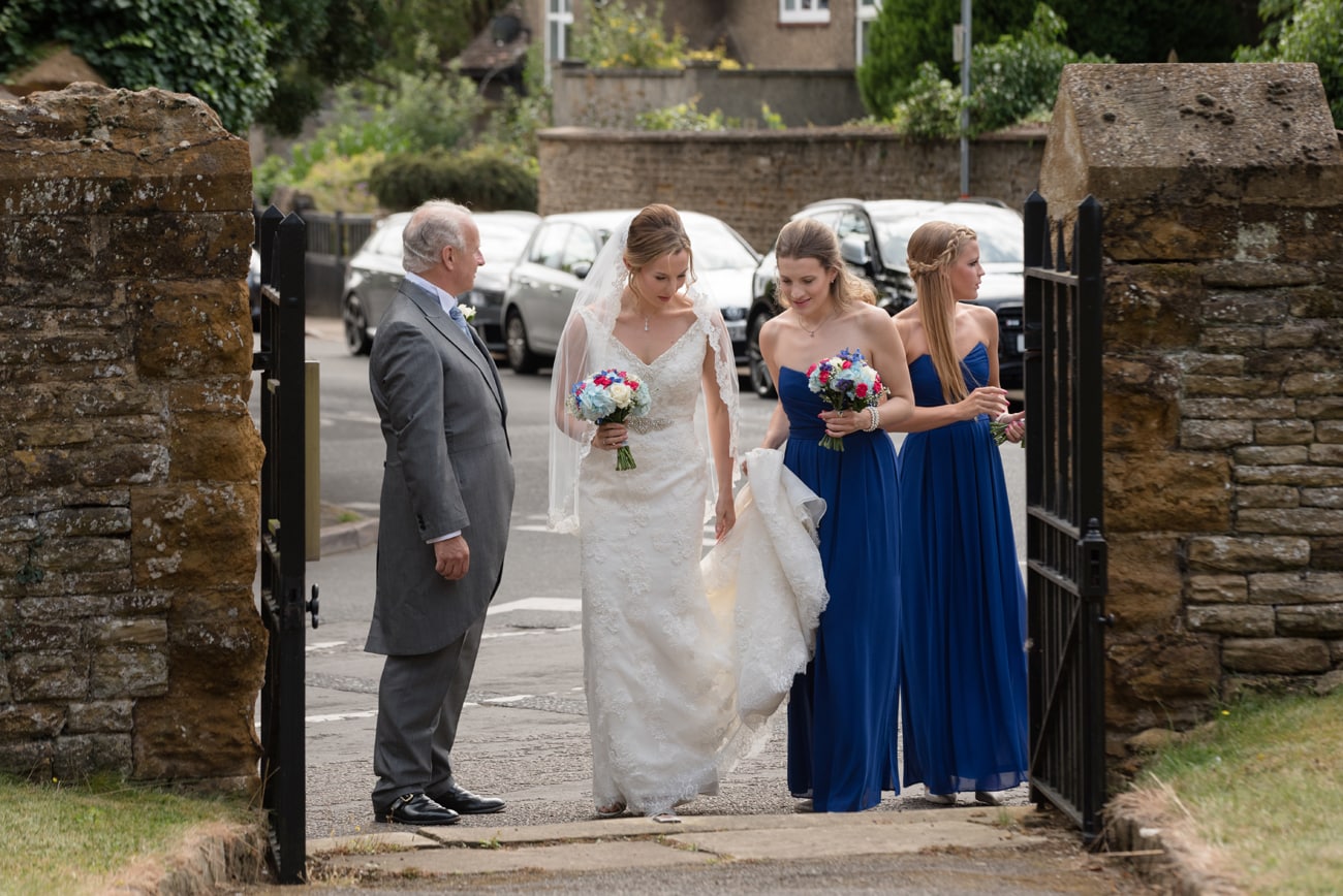 Bride, her dad, and bridesmaids arriving at St Peter's church in Weston Favell