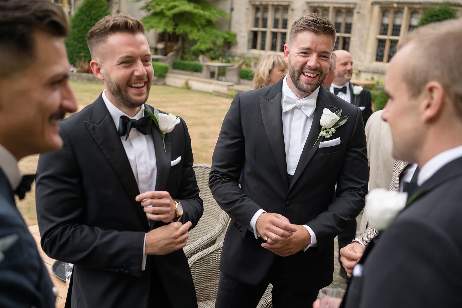 Groom and best man laughing with the ushers