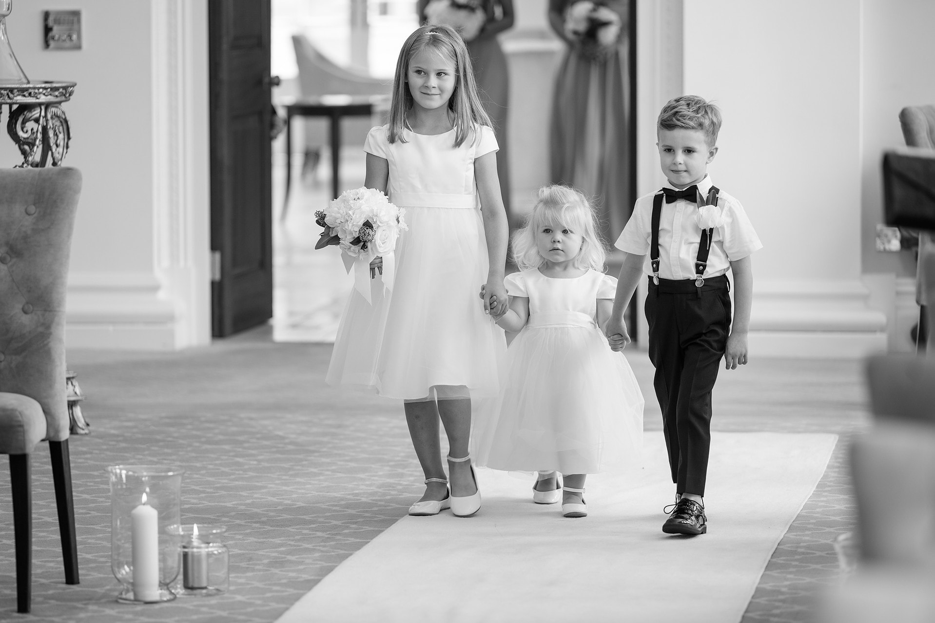 Flower girls and pageboy walking down the aisle
