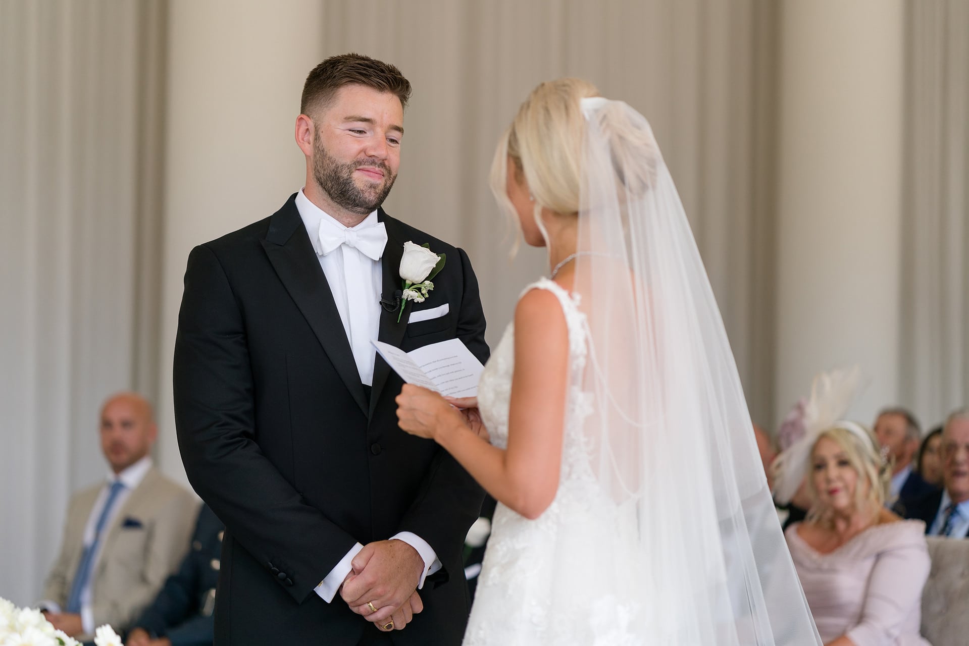 Groom looking lovingly at bride as she makes her vows