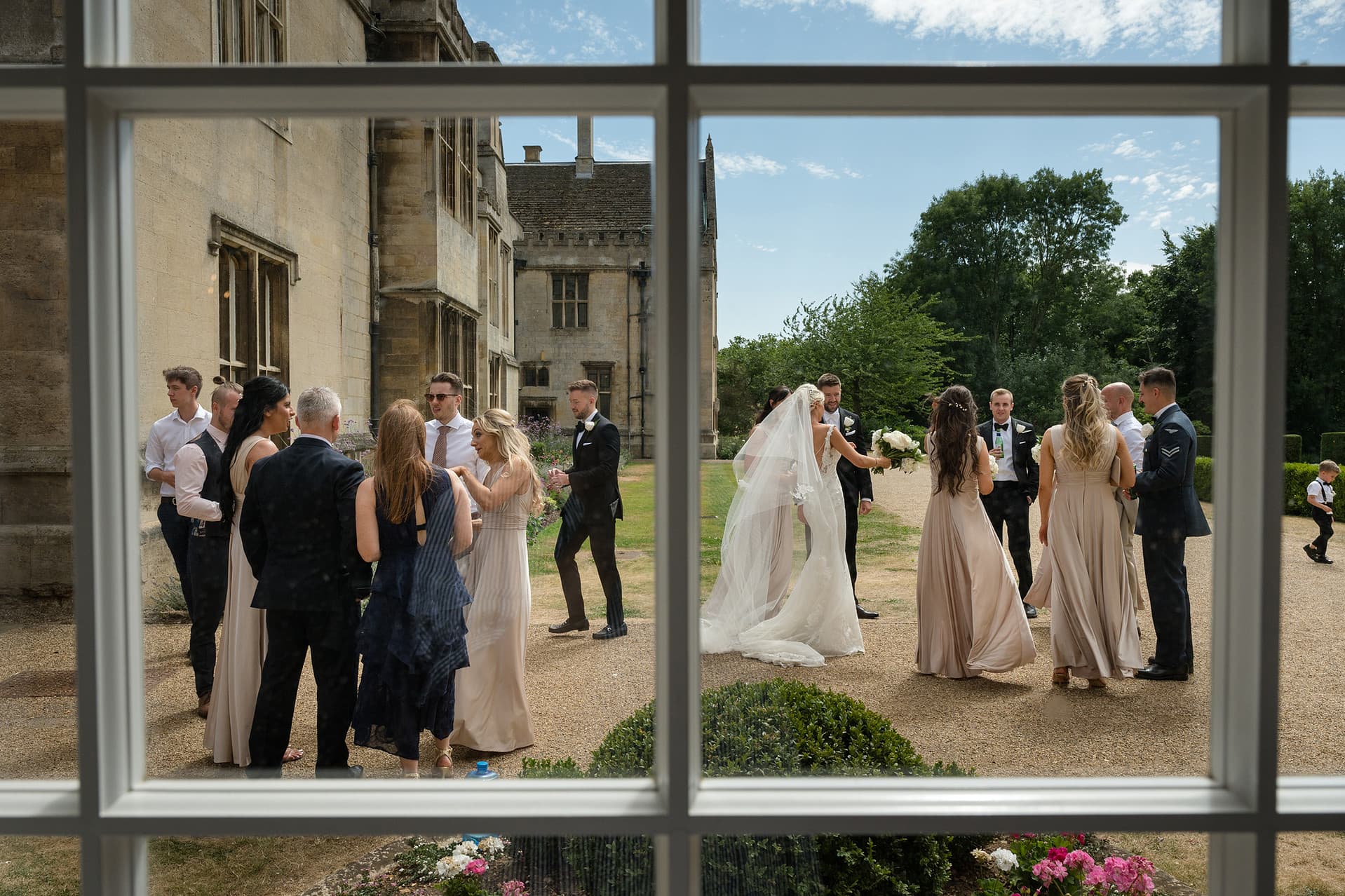 View of wedding drinks reception through panes of glass in an orangery window