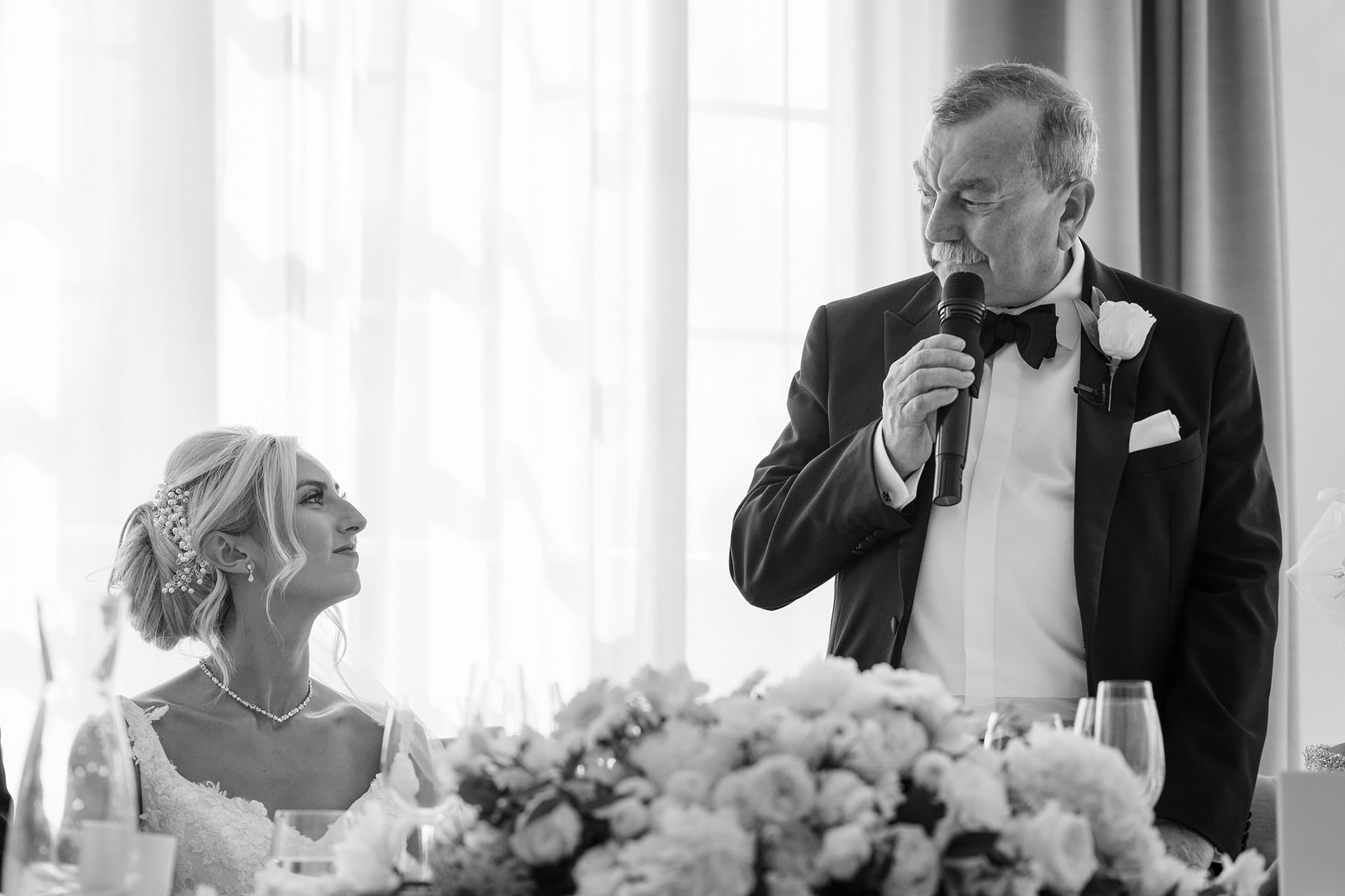 Father of the bride and bride looking at each other during his speech