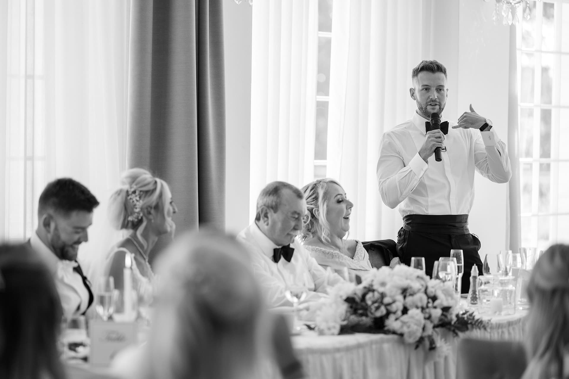 Best man making a 'phone' gesture with his hand during speech