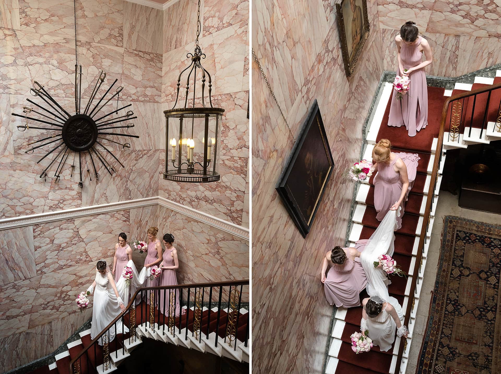 Bridesmaids carrying the bride's train as they all walk down the stairs at Courteenhall house